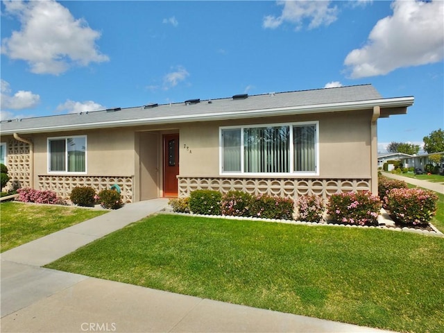 single story home featuring a front yard and stucco siding