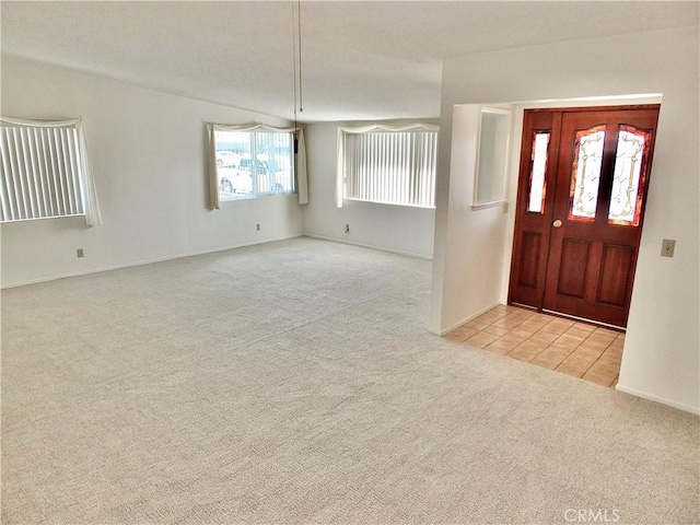 carpeted entrance foyer featuring tile patterned flooring