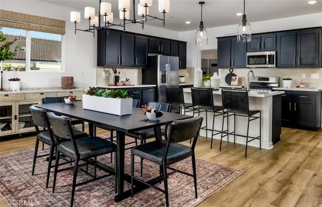 dining space with an inviting chandelier, recessed lighting, and light wood-type flooring