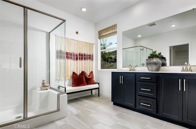 full bath with visible vents, double vanity, recessed lighting, a stall shower, and a sink