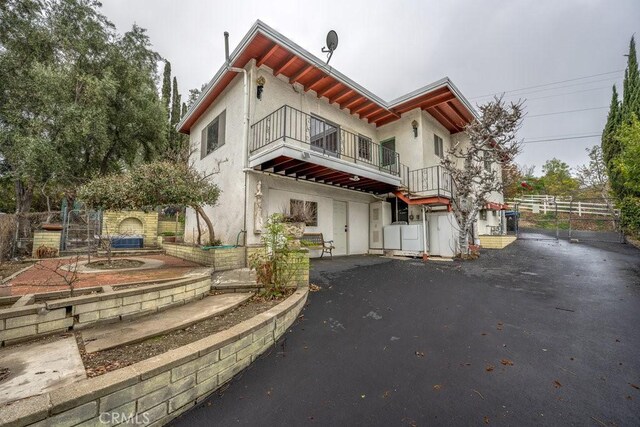 10670 Olive Grove Ave, Sunland, CA 91040 - rear view of property featuring a balcony, stucco siding, fence, and a patio