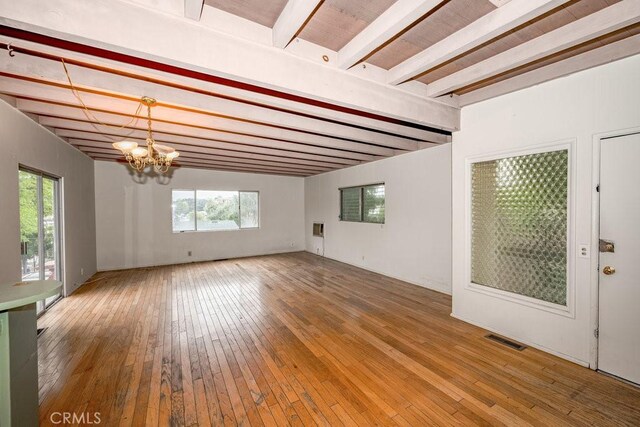 10670 Olive Grove Ave, Sunland, CA 91040 - unfurnished living room featuring beamed ceiling, a chandelier, wood-type flooring, and plenty of natural light