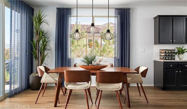 dining area with baseboards and light wood-style floors