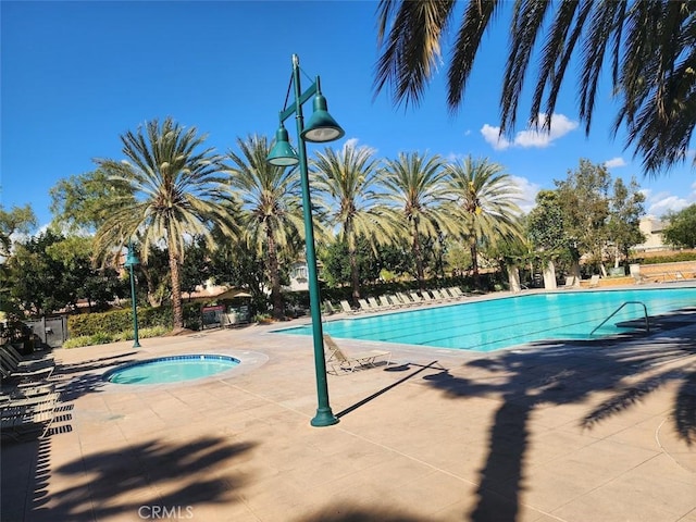 community pool with a patio area and a community hot tub