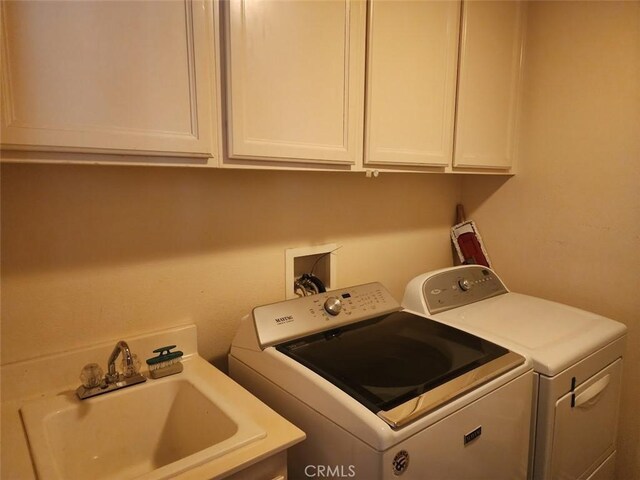 laundry area featuring cabinet space, washing machine and dryer, and a sink
