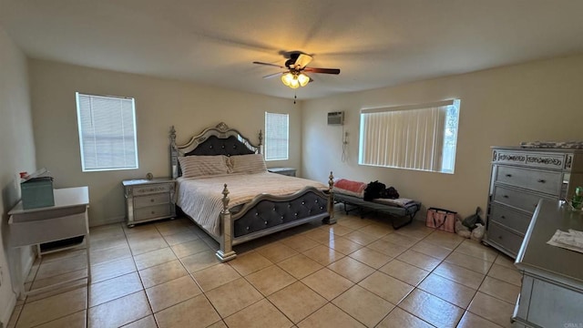 bedroom featuring light tile patterned floors, an AC wall unit, and a ceiling fan