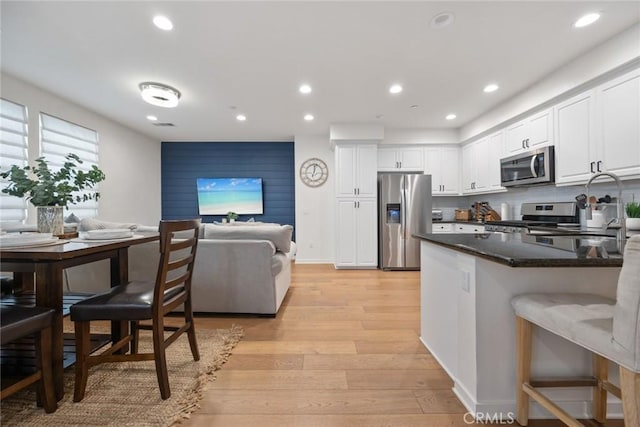 kitchen with recessed lighting, stainless steel appliances, light wood-style floors, and white cabinetry