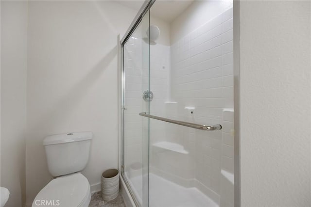 bathroom featuring a shower stall and toilet