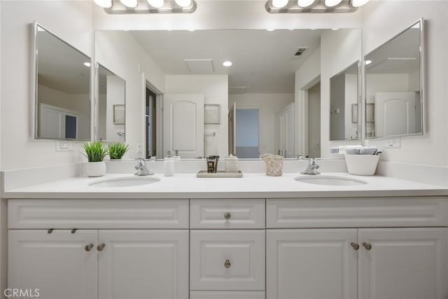 bathroom with a sink, visible vents, and double vanity