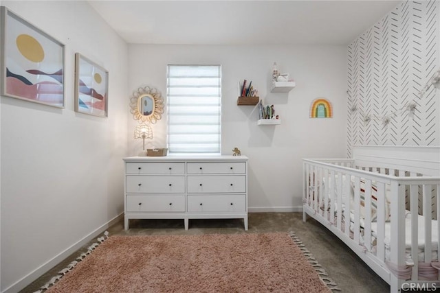 unfurnished bedroom with baseboards, a crib, and carpet floors