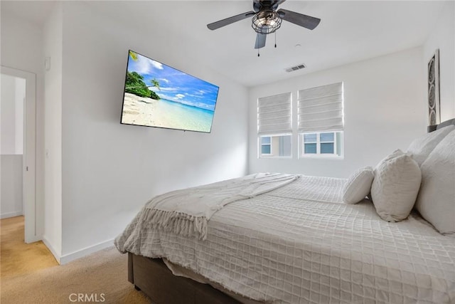 bedroom featuring visible vents, light colored carpet, baseboards, and ceiling fan