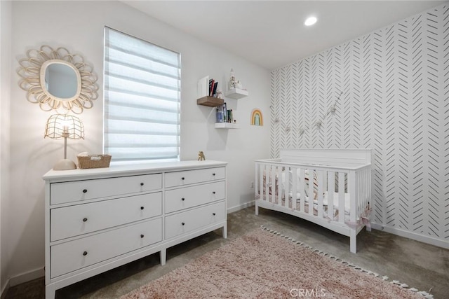 carpeted bedroom with recessed lighting, baseboards, and a nursery area