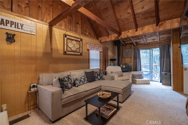 23679 Hillside Dr, Crestline, CA 92325 - living room featuring carpet floors, wood walls, a wood stove, beam ceiling, and wood ceiling
