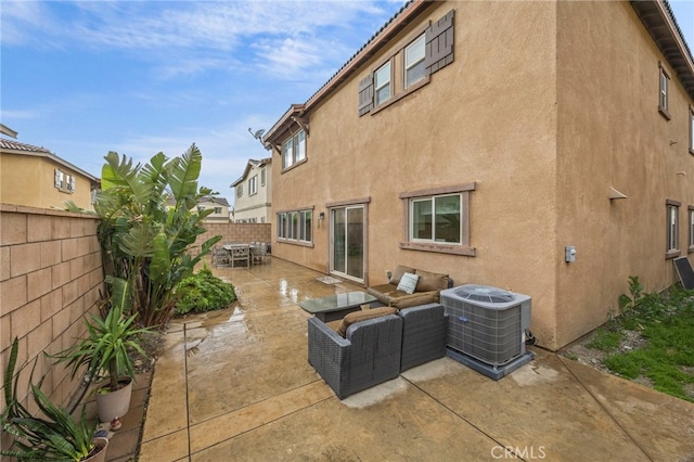 back of property with stucco siding, central AC, a fenced backyard, and a patio area