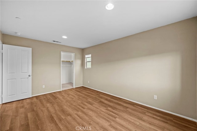 unfurnished bedroom featuring recessed lighting, baseboards, light wood finished floors, visible vents, and a closet