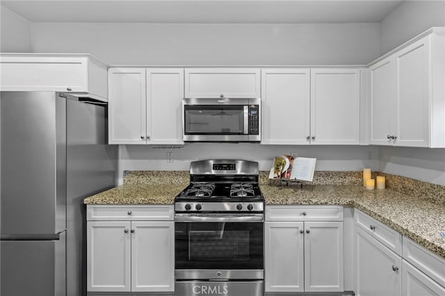 kitchen featuring white cabinetry, stainless steel appliances, and light stone countertops