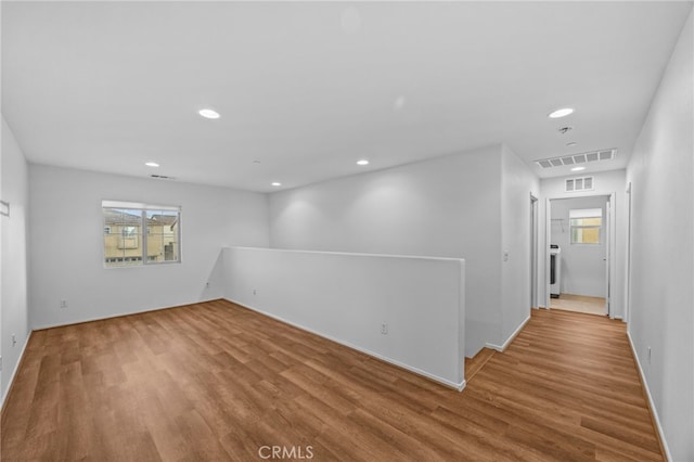 spare room featuring wood finished floors, plenty of natural light, recessed lighting, and visible vents