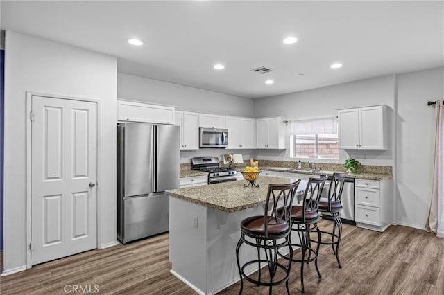 kitchen featuring white cabinets, a kitchen island, dark wood-style flooring, and appliances with stainless steel finishes