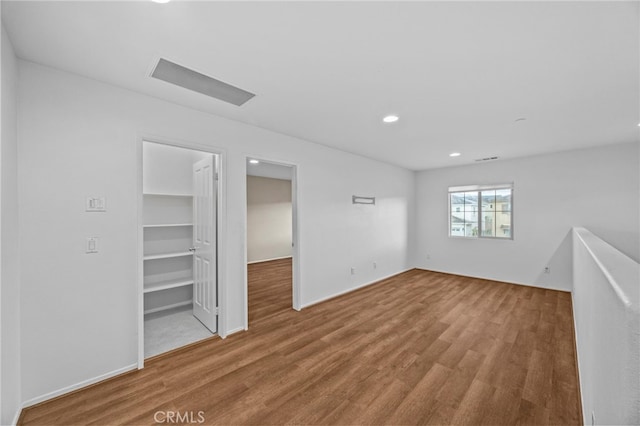 empty room with wood finished floors and recessed lighting