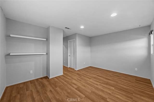 unfurnished room with baseboards, visible vents, recessed lighting, and wood finished floors