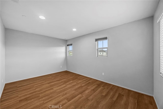empty room with wood finished floors and recessed lighting