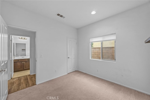 unfurnished bedroom featuring light carpet, baseboards, and visible vents