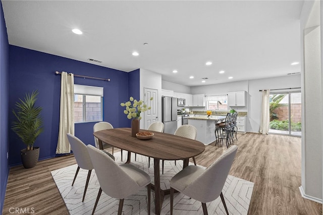 dining area with light wood-type flooring, recessed lighting, and visible vents