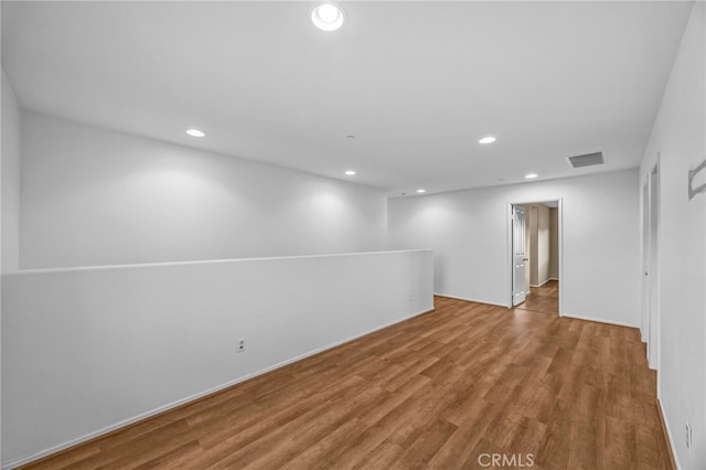 basement with wood finished floors, recessed lighting, and visible vents