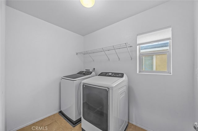 washroom featuring washing machine and dryer, baseboards, and laundry area