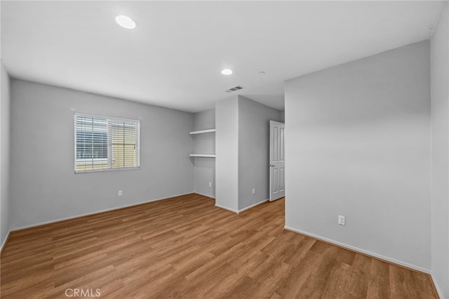spare room with wood finished floors, recessed lighting, and visible vents