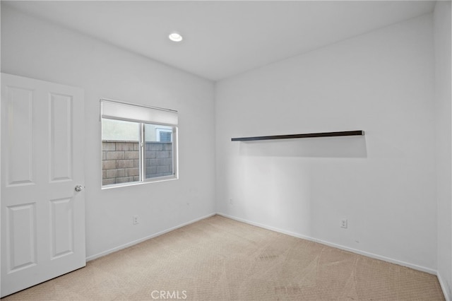 empty room with baseboards, recessed lighting, and carpet