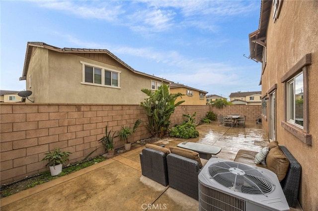 view of patio with a fenced backyard, outdoor dining space, an outdoor hangout area, and cooling unit