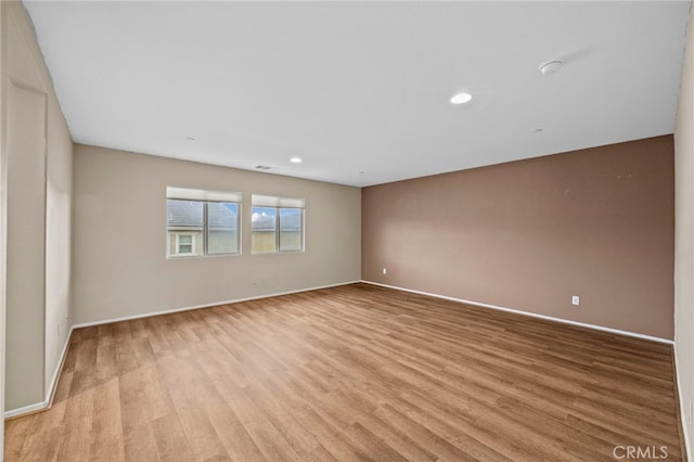 spare room with baseboards, visible vents, light wood-style floors, and recessed lighting