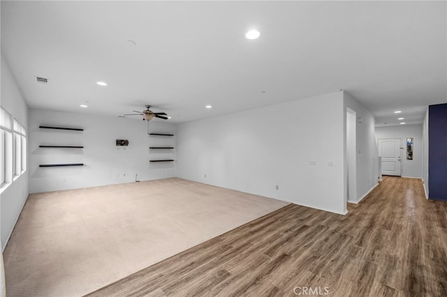 empty room with a ceiling fan, wood finished floors, recessed lighting, visible vents, and carpet