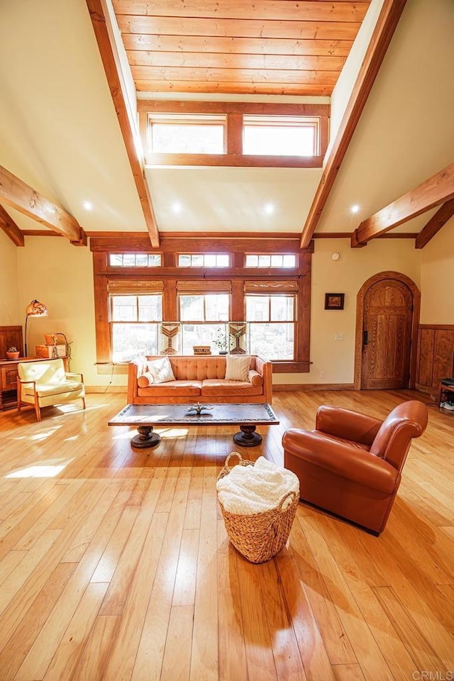 living area with hardwood / wood-style floors, beam ceiling, baseboards, and high vaulted ceiling