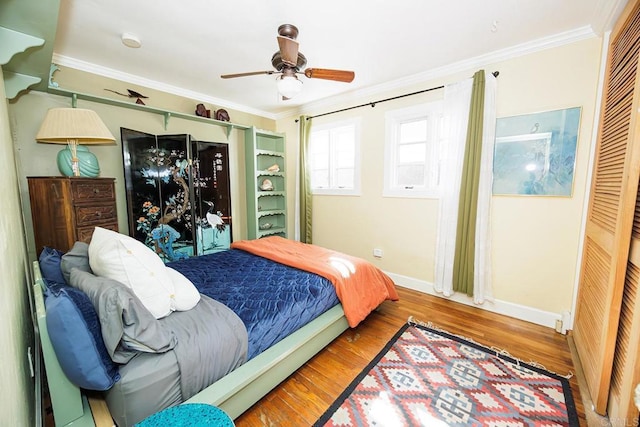 bedroom featuring ceiling fan, crown molding, baseboards, and wood finished floors