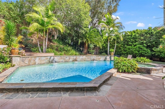 pool featuring a patio area and an in ground hot tub