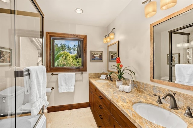 bathroom with baseboards, a sink, double vanity, and a stall shower