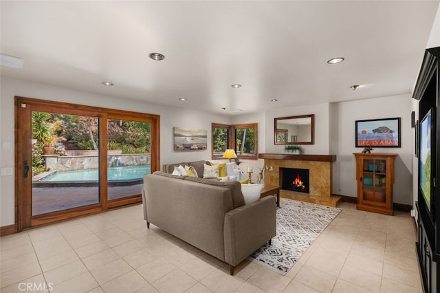living area featuring light tile patterned floors, baseboards, recessed lighting, and a fireplace