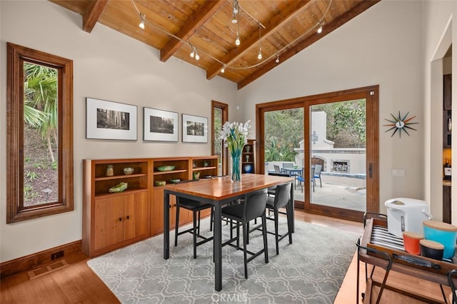dining room with wood ceiling, beamed ceiling, light wood finished floors, and baseboards