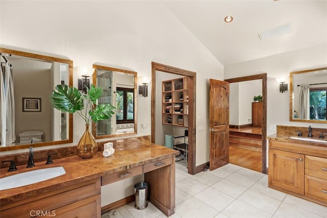 bathroom featuring tile patterned floors, high vaulted ceiling, and vanity