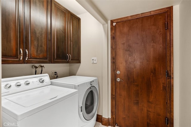 clothes washing area featuring independent washer and dryer and cabinet space