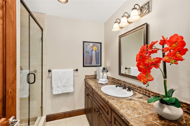 full bathroom with tile patterned floors, a shower stall, vanity, and baseboards