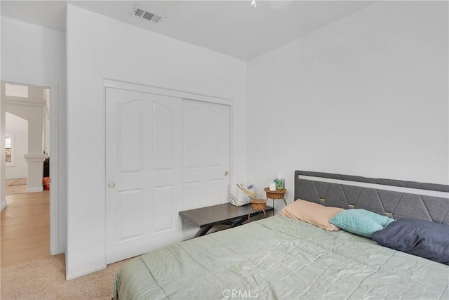 bedroom with visible vents, a closet, and carpet flooring