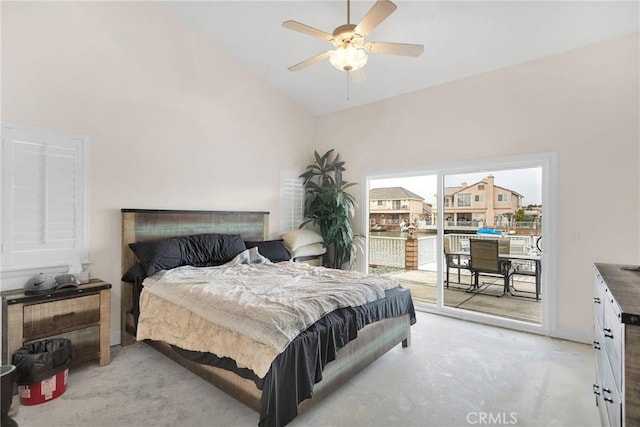 bedroom featuring concrete floors, baseboards, ceiling fan, high vaulted ceiling, and access to outside