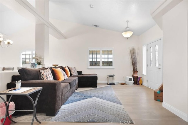 living area with visible vents, a notable chandelier, a healthy amount of sunlight, and wood finished floors