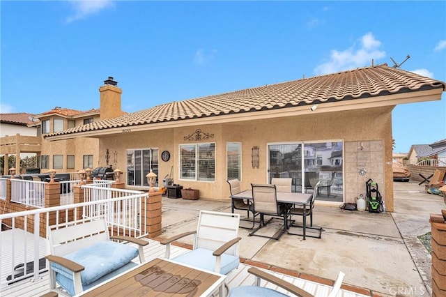 exterior space with a patio area, outdoor dining space, stucco siding, and a tile roof