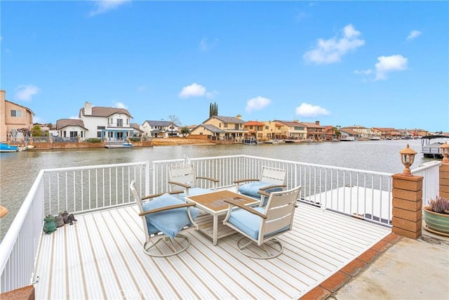 wooden terrace featuring a residential view and a water view