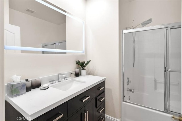 bathroom featuring visible vents, shower / bath combination with glass door, and vanity