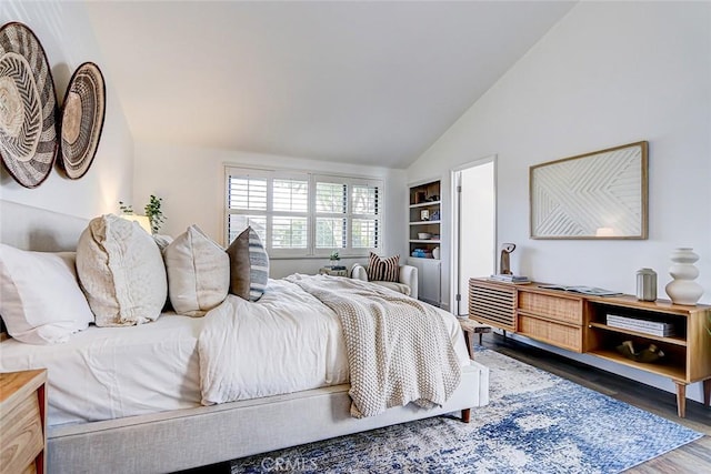 bedroom with vaulted ceiling and wood finished floors